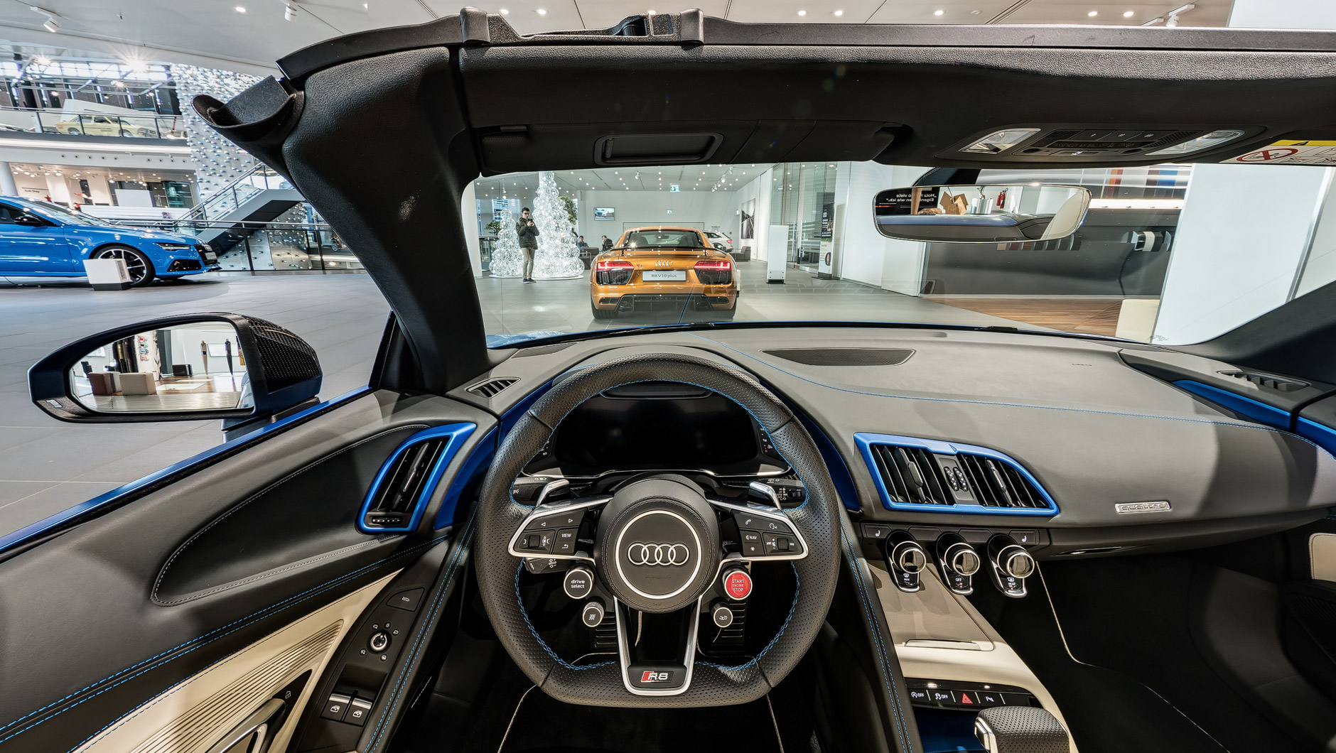 Exklusiver Innenraum / Interior eines Audi R8 Spyder in Arablau Matteffekt. Durch die Windschutzscheibe ist noch ein weiterer R8 zu sehen.