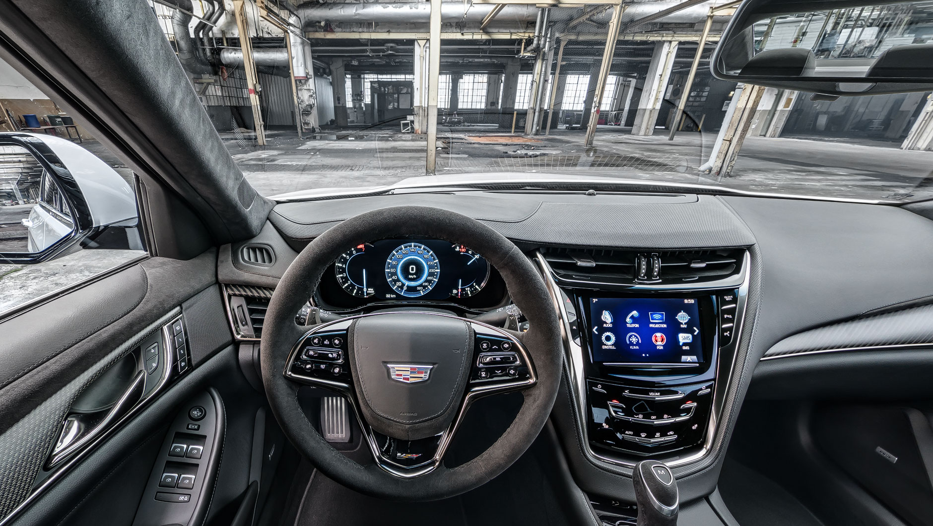 Autoinnenraum / Interior eines Cadillac CTS-V. Foto aufgenommen aus der Perspektive des Fahrers. Das Auto steht in einer alten, stillgelegten Fabrikhalle.