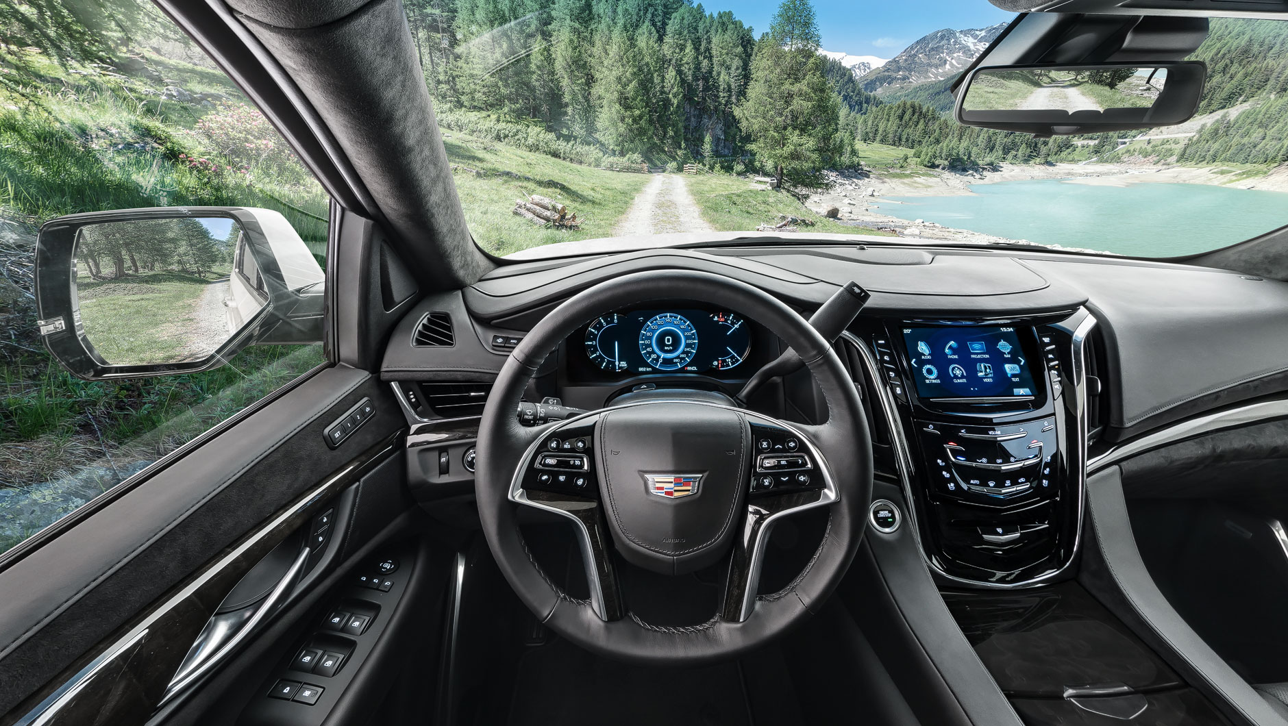 Autoinnenraum / Interior eines Cadillac Escalade. Foto aufgenommen aus der Fahrerperspektive. Der Geländewagen fährt auf einer schmalen Schotterstraße in den Alpen von Italien.