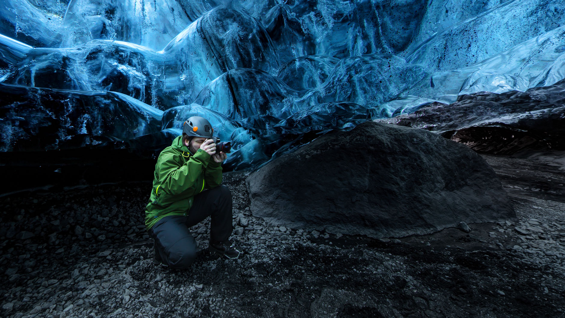 Höhle in einem isländischen Gletscher. Ein Fotograf fotografiert das blaue Eis.